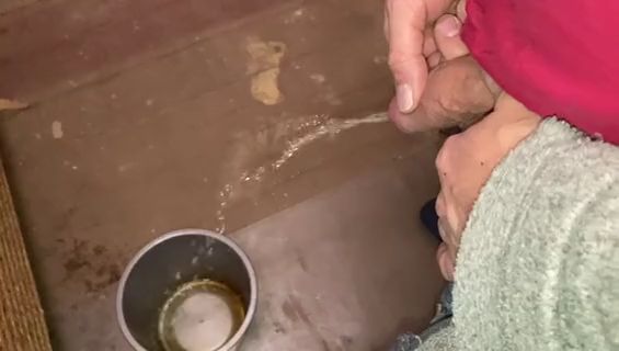 Thumbnail of Pissing in a bucket in the camp